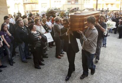 Allegados de una de las tres menores conducen su féretro al interior de la iglesia para el funeral.