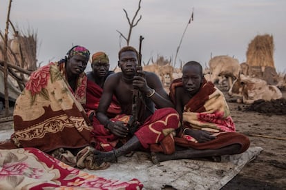 Los sudaneses de la tribu Dinka posan con un rifle temprano en la mañana en su campamento de ganado en Mingkaman, en el estado de Lagos (Sudán del Sur).