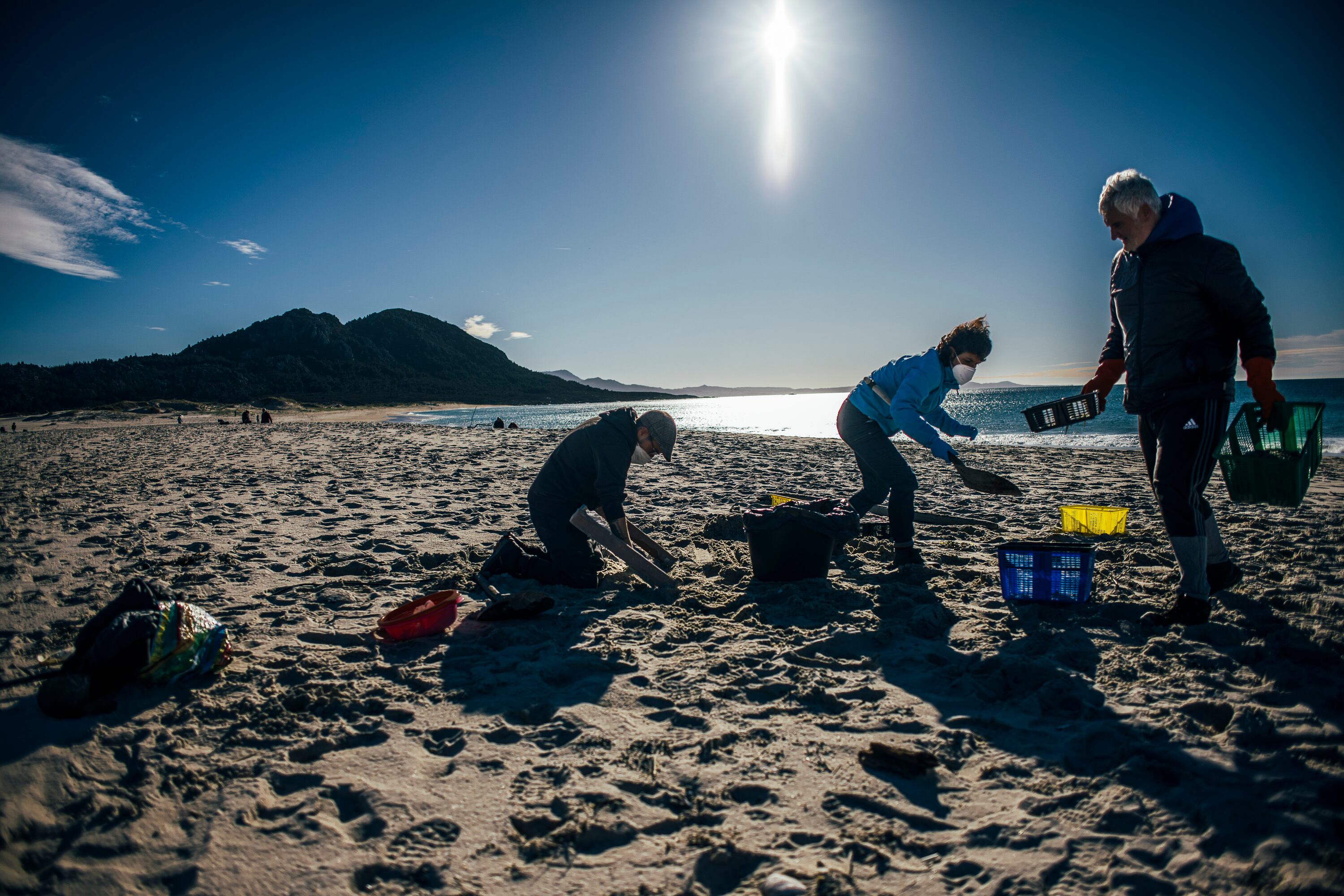 Tareas de limpieza de 'pellets' a cargo de voluntarios en la playa de Area Maior, en Muros (A Coruña).