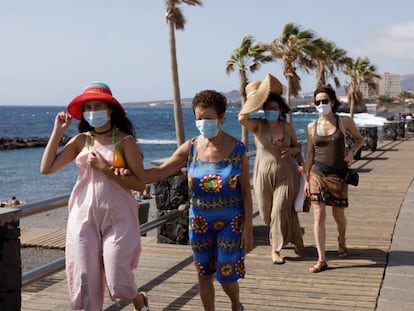 Unos turistas caminan por un paseo cercano a la playa de Las Caletillas, en el municipio de Candelaria (Tenerife). EFE/Ramón de la Rocha/Archivo