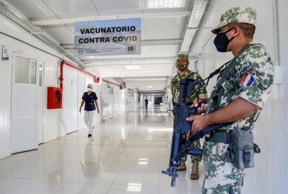 Soldados paraguayos hacen guardia mientras los trabajadores de salud inoculan a sus colegas con la vacuna rusa Sputnik V en un hospital de Itaugua, Paraguay, el 22 de febrero.