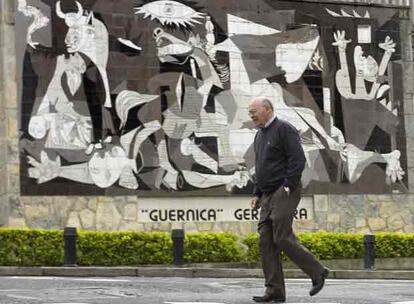 Un hombre pasea ante el mural 'Guernica', reproducción de la obra de Pablo Picasso, en el día de la conmemoración del 70 aniversario del bombardeo de esta ciudad vizcaína. El cuadro original, que se encuentra en el museo Reina Sofía de Madrid, es reclamado año tras año por el Ayuntamiento de Gernika para su exposición en el País Vasco. A falta de cuadro, se exponen en la localidad entre 20 y 30 dibujos con los que el pintor malagueño preparó la elaboración del Gernika.