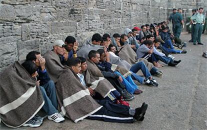 Un grupo de inmigrantes se tapa con mantas tras su llegada ayer al puerto de Tarifa (Cádiz).
