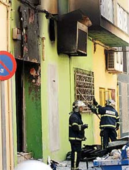 Varios bomberos en la puerta del local <i>El Cubanito</i> tras controlar el incendio.