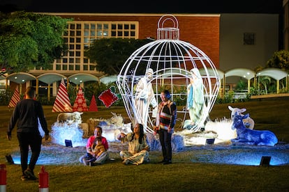 A family takes a photo next to a Nativity scene as part of Christmas celebrations in Caracas, Venezuela.
