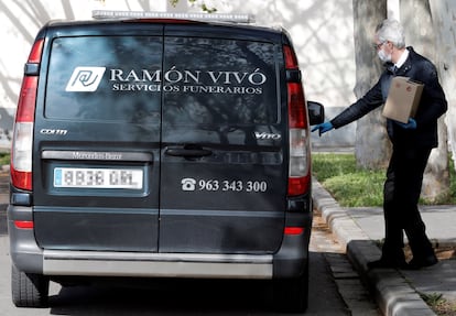 A worker from a funeral service collects the ashes of a coronavirus victim in Valencia.