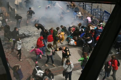 El público asistente al Maratón de Boston se tapa los oídos momentos después de que explotara la segunda bomba en la línea de meta, Boston (EE UU), 15 de abril de 2013.