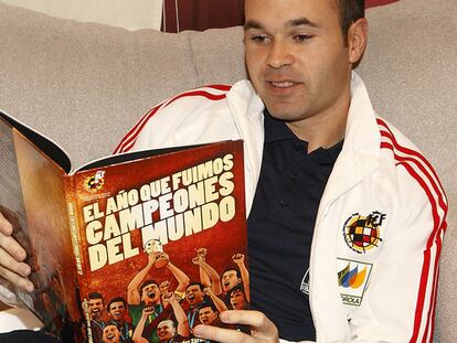 Iniesta lee el cómic 'El año que fuimos campeones del mundo'.