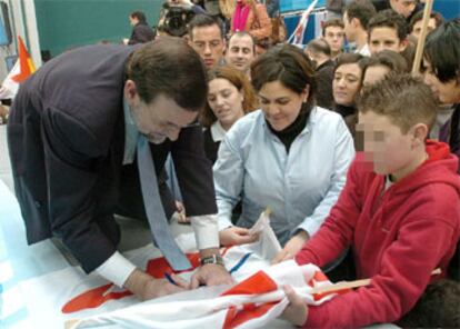 El candidato del PP firma autógrafos en un acto con simpatizantes en la capital riojana.