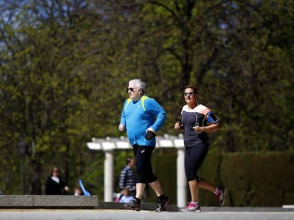 Dos personas corren por el parque del Retiro de Madrid.