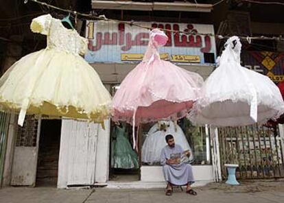 Un comerciante de Bagdad lee el periódico ante el escaparate de su tienda de vestidos de novia.