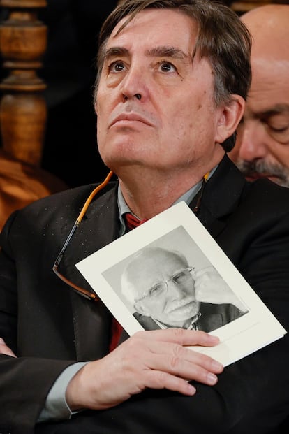 El director del Instituto Cervantes, Luis García Montero, sostiene un retrato del escritor español Luis Mateo Díez.