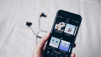 Un iPhone muestra el menú de 'podcasts' de Spotify