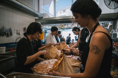 Voluntarias sacan panes en la cocina comunitaria de Nation Station en Beirut.