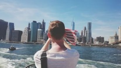 Un hombre fotografía Nueva York desde un ferri.