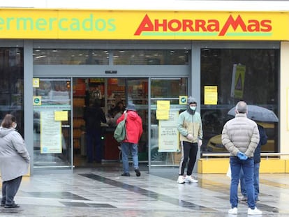 Varias personas esperan para poder entrar a comprar en un supermercado de Madrid en plena crisis sanitaria por coronavirus.