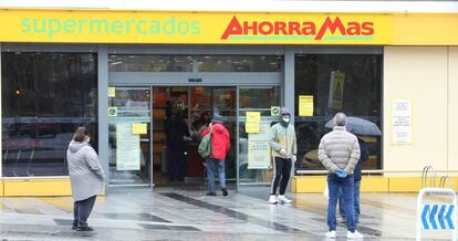 Varias personas esperan para poder entrar a comprar en un supermercado de Madrid en plena crisis sanitaria por coronavirus.
