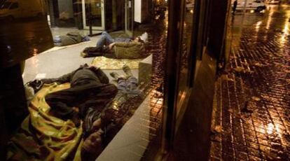 Varios indigentes durmiendo el pasado martes por la noche en un cajero de Barcelona.