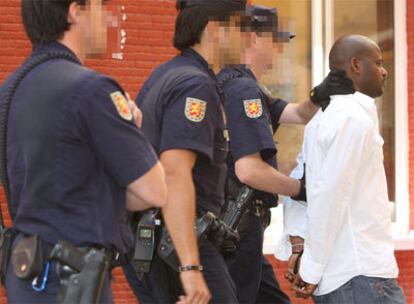 La policía trasladaba ayer a uno de los detenidos durante la operación desarrollada en Málaga.