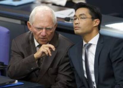 El ministro de Economía alemán, Philipp Roesler (d), y el de Finanzas, Wolfgang Schäuble, conversan durante una sesión del 'Bundestag' o Parlamento alemán, en Berlín, Alemania. EFE/Archivo