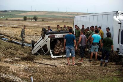 Soldados macedonios rodean un coche volcado tras la inundación. El ejército ha intervenido para ayudar a los ciudadanos.