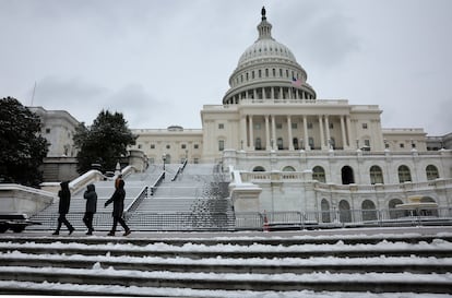 People walk past a snowy U.S. Capitol building in Washington, U.S., January 16, 2024