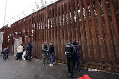 Federal officers remove handcuffs from men before releasing them through a gate in a border wall to Tijuana, Mexico