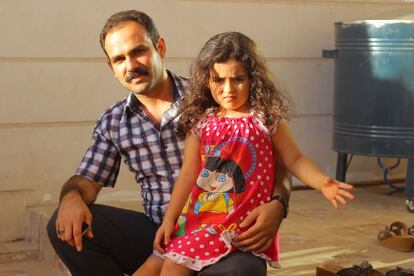 Hassan Ahmed Peraly junto a su hija en la entrada de su casa, en la ciudad iraquí de Khanaqin.