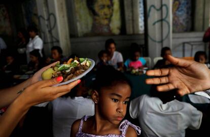 Un par de voluntarios reparten comida en Caracas, en mayo pasado.