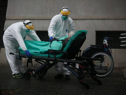 Personal sanitari trasllada a l'hospital una dona contagiada per coronavirus, a Barcelona.