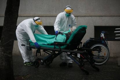 Personal sanitari trasllada a l'hospital una dona contagiada per coronavirus, a Barcelona.