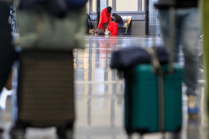 Dos pasajeros aguardan durante la mañana de este martes en la estación de Alicante donde Cruz Roja Comunitat Valenciana ha instalado puntos de atención en para ofrecer respuesta básica a las personas que lo necesiten tras el apagón eléctrico.

