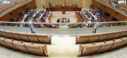 Hemiciclo de la Asamblea de Madrid con la tribuna de invitados vacía por orden del presidente de la Cámara.