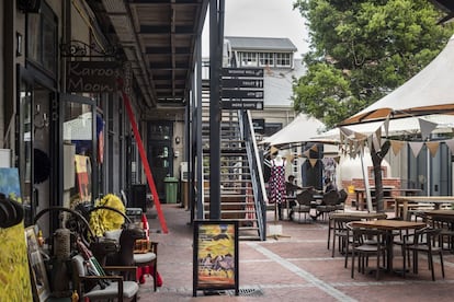 En The Old Biscuit Mill, un antiguo molino del gentrificado barrio de Woodstock que salió del olvido cuando lo reconvirtieron en galería comercial de aires hípster, no hay ni un alma. Un vistazo a este centro de artesanía y moda alternativa da fe de los difíciles momentos de la ciudad: donde antes había ríos de turistas apretujados por cada tienda y recoveco comprando bisutería, moda u objetos de decoración, ahora hay vacío. En la terraza de uno de los restaurantes, los dos únicos clientes son dos chicos jóvenes que trastean con sus ordenadores portátiles con la única compañía de una taza de café.