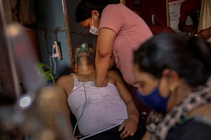 Manisha Bashu presiona el pecho de su padre, que tenía dificultades para respirar, después de que se quedara inconsciente mientras recibía oxígeno en un templo sij en Ghaziabad, India, en plena ola de coronavirus, el 30 de abril de 2021. Los Pulitzer han premiado el trabajo continuado de la agencia Reuters en su cobertura gráfica de la pandemia en la India.
