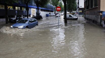 Fue una tormenta móvil. Durante tres horas la lluvia viajó del noroeste al sureste de Madrid, desde Galapagar hasta Alcalá. Tuvo un efecto doméstico: inundó sótanos y garajes. Convirtió algunas calles en piscinas (en la imagen tomada desde la calle Miguel Yuste). Y provocó retrasos de hasta 20 minutos en los vuelos del aeropuerto de Madrid-Barajas.