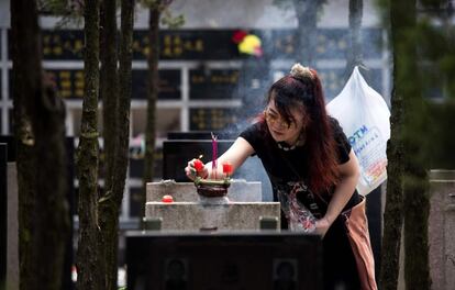 A woman burns incense at a grave during the annual "Qingming" festival, or Tomb Sweeping Day, at a public cemetery in Shanghai on April 4, 2016. 
During Qingming, Chinese traditionally tend the graves of their departed loved ones and often burn paper offerings to honour them and keep them comfortable in the afterlife. / AFP PHOTO / JOHANNES EISELE