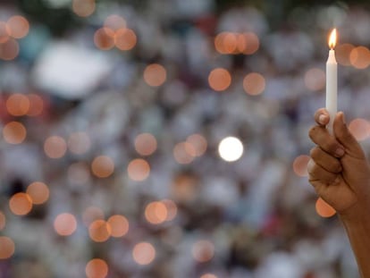 Fiel segura uma vela em uma cerim&ocirc;nia religiosa pela paz.