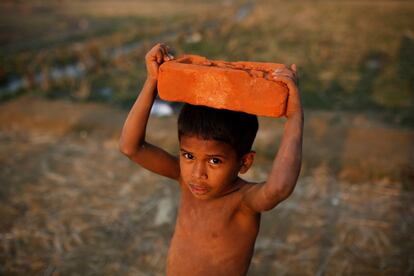 Un niño refugiado ronhingya lleva un ladrillo en el campamento de refugiados Balukhali, cerca de Cox's Bazar (Bangladés).
