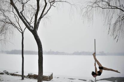 Un miembro del equipo nacional de danza de China realizando entrenos en un parque nevado en la ciudad de Tianjin, China.