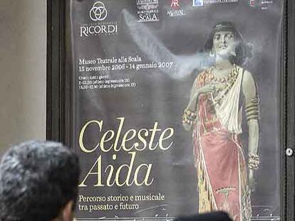 Una pareja, delante de la puerta de La Scala, contempla el cartel de <i>Aida.