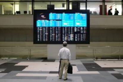 Un hombre observa una pantalla en la que aparece información bursátil en Tokio.