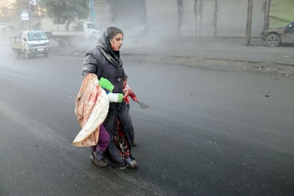 Una mujer siria herida camina con sus hijos después de los ataques aéreos en una zona rebelde de la norteña ciudad devastada por la guerra de Alepo.