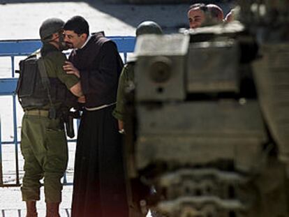 Un fraile de la iglesia de la Natividad besa a un soldado israelí al salir del templo.