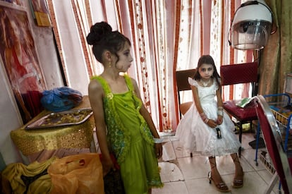 Dos chicas en un salón de belleza, vestidas y maquilladas para la boda de un familiar en Kabul, 2009.