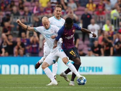 El jugador del PSV trata de robarle el balón al jugador del Barcelona Ousmane Dembelé.