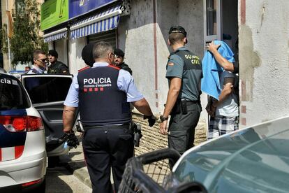 Uno de los detenidos sale de su domicilio en la calle Pont d'Olot de Ripoll.