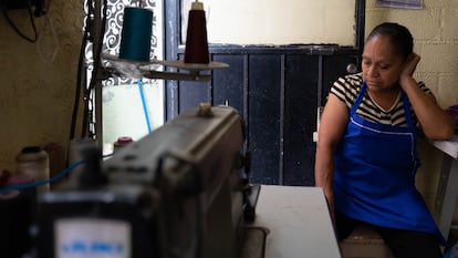 Domitila Miranda sentada junto a su máquina de coser.