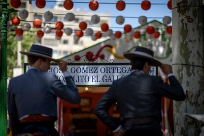 Dos jinetes frente al cartel de la calle del reciento ferial, Joselito El Gallo, dedicadas a toreros, el lunes de Feria en Sevilla. 