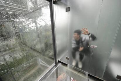 Un turista visitando los baños públicos de paredes de cristal en el Lago Shiyan, en el centro de la provincia de Hunan (China).